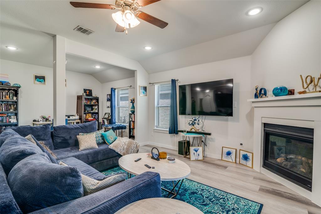 4204 Bullock Lane Forney, TX 75126 - Photo 4 of 25 a living room with furniture a flat screen tv and a fireplace