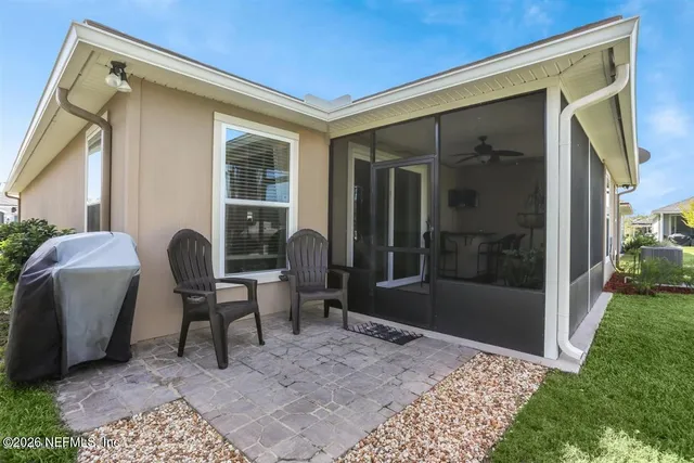 a view of a patio with a table and chairs and a yard