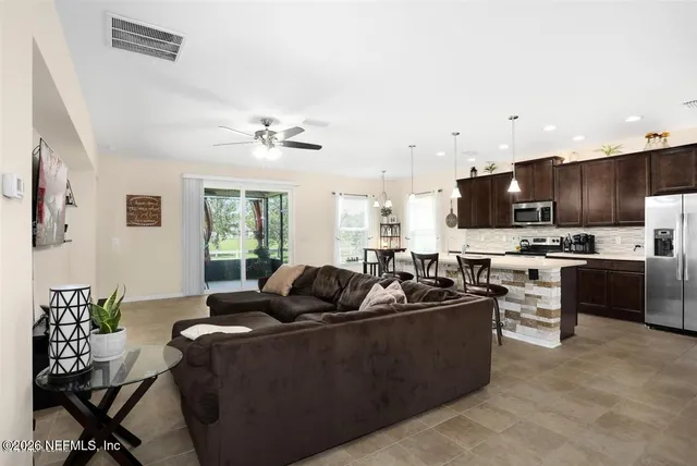 a living room with furniture kitchen area and a window