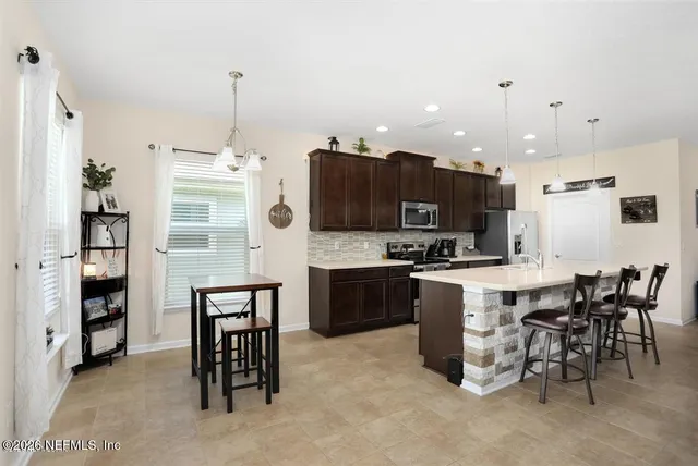 a large kitchen with kitchen island a dining table and chairs