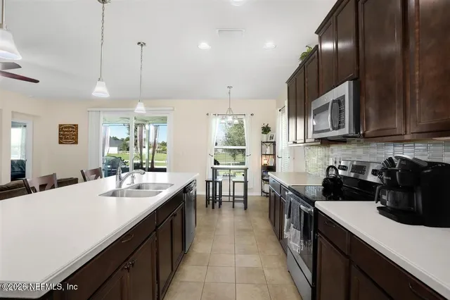 a kitchen with lots of counter space a sink appliances and cabinets