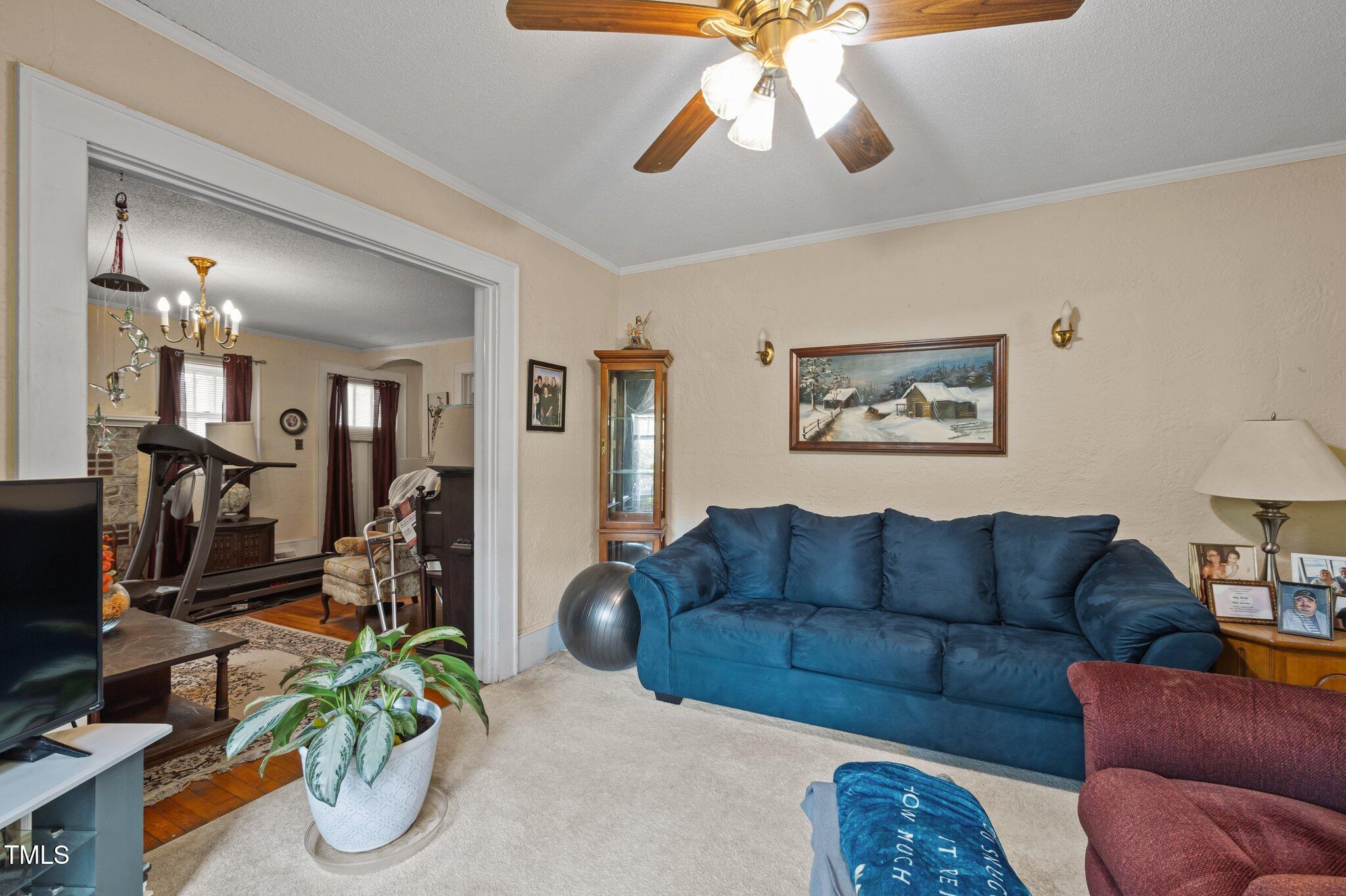 1823 East Geer Street Durham, NC 27704 - Photo 33 of 55 a living room with furniture a chandelier and a flat screen tv