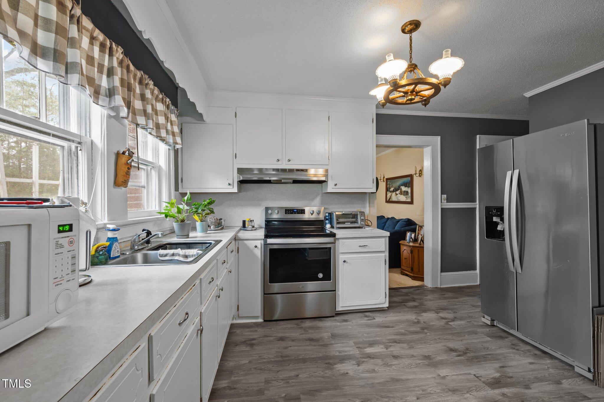 1823 East Geer Street Durham, NC 27704 - Photo 36 of 55 a kitchen with stainless steel appliances a sink stove and refrigerator