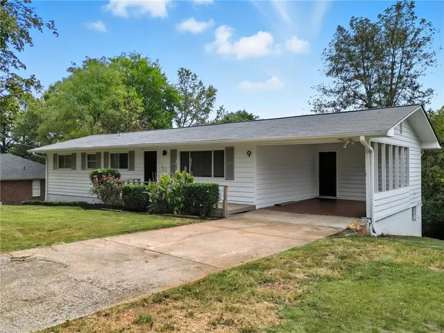 a front view of a house with a yard and potted plants