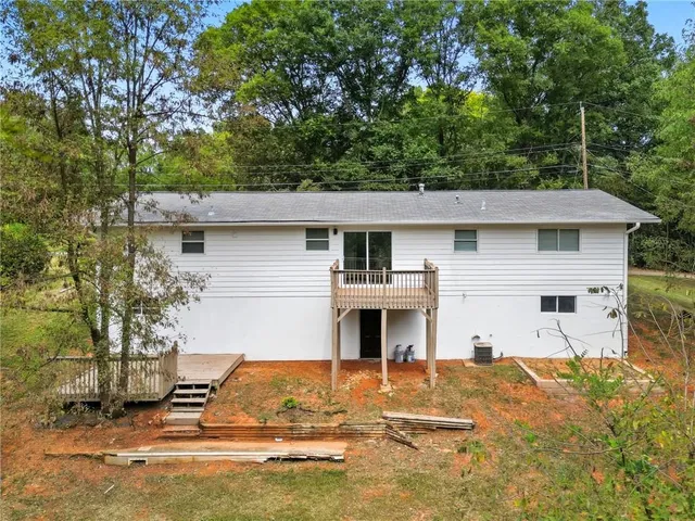 a view of a house with backyard and trees