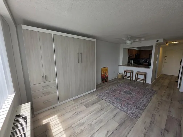 a view of a hallway to an empty room and wooden floor