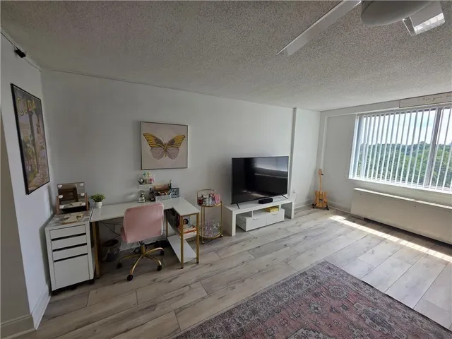 a view of a livingroom with workspace and a window