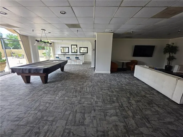 a living room with furniture a flat screen tv and a large window