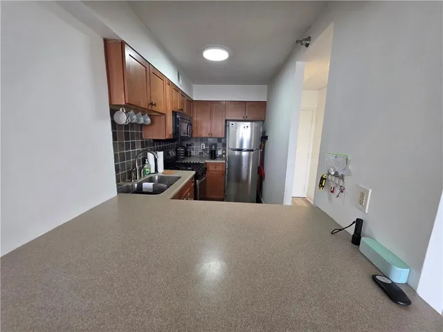 a view of a kitchen with a sink and a refrigerator