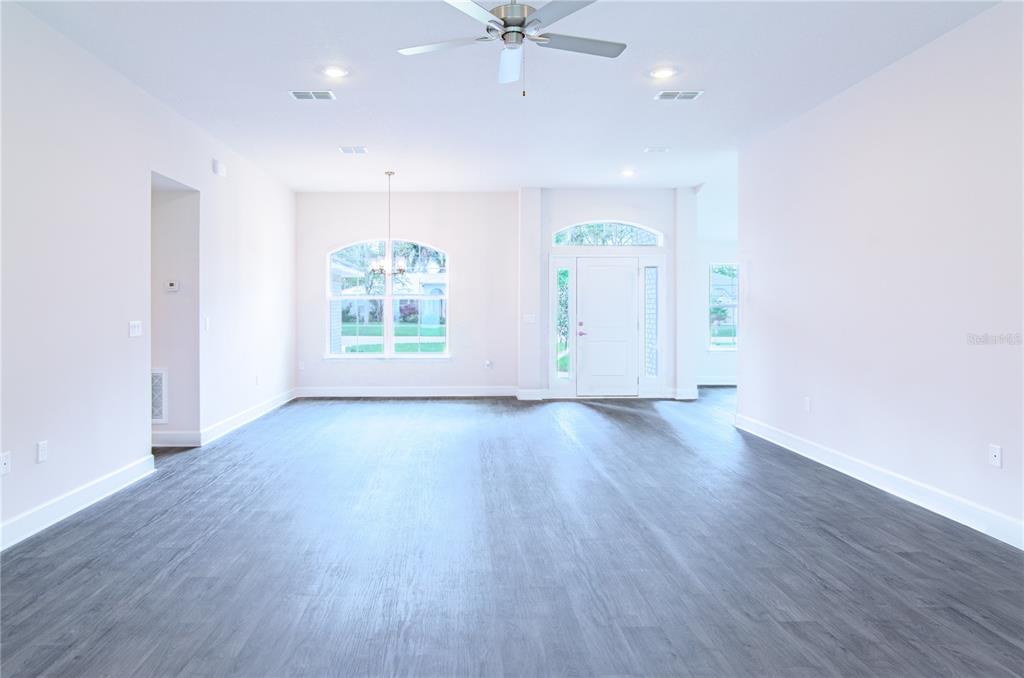 5 Red Clover Lane Palm Coast, FL 32164 - Photo 14 of 38 an empty room with wooden floor chandelier fan and windows