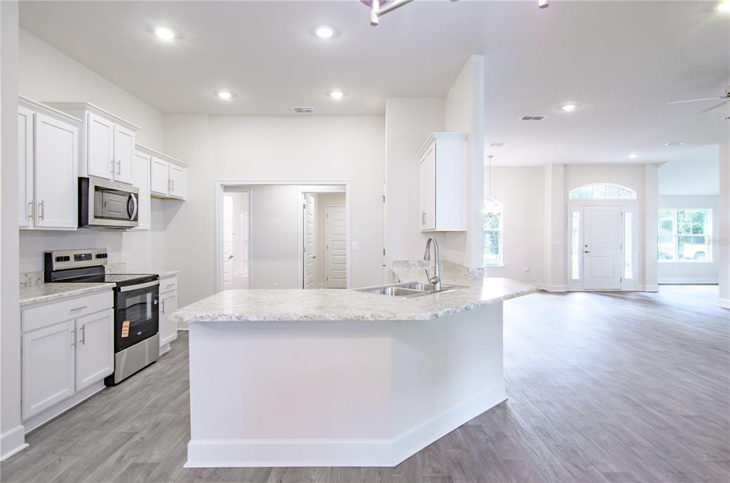 5 Red Clover Lane Palm Coast, FL 32164 - Photo 16 of 38 a large kitchen with stainless steel appliances granite countertop a lot of counter space and wooden floor