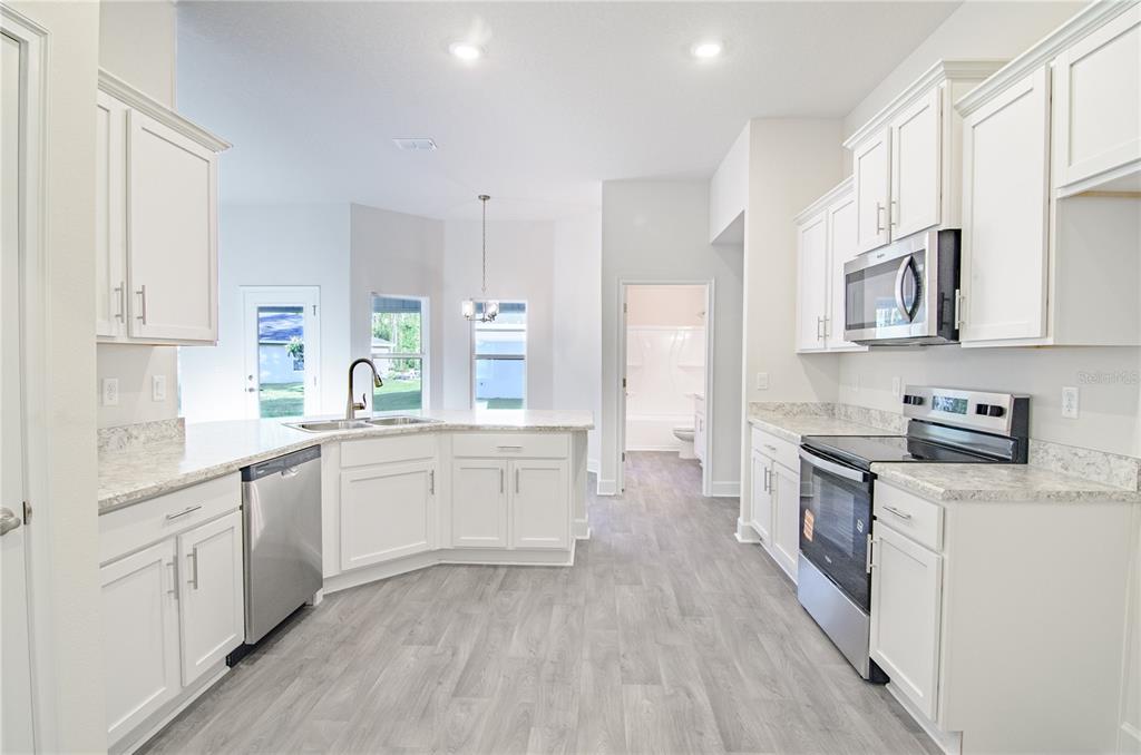 5 Red Clover Lane Palm Coast, FL 32164 - Photo 18 of 38 a kitchen with granite countertop white cabinets and white appliances