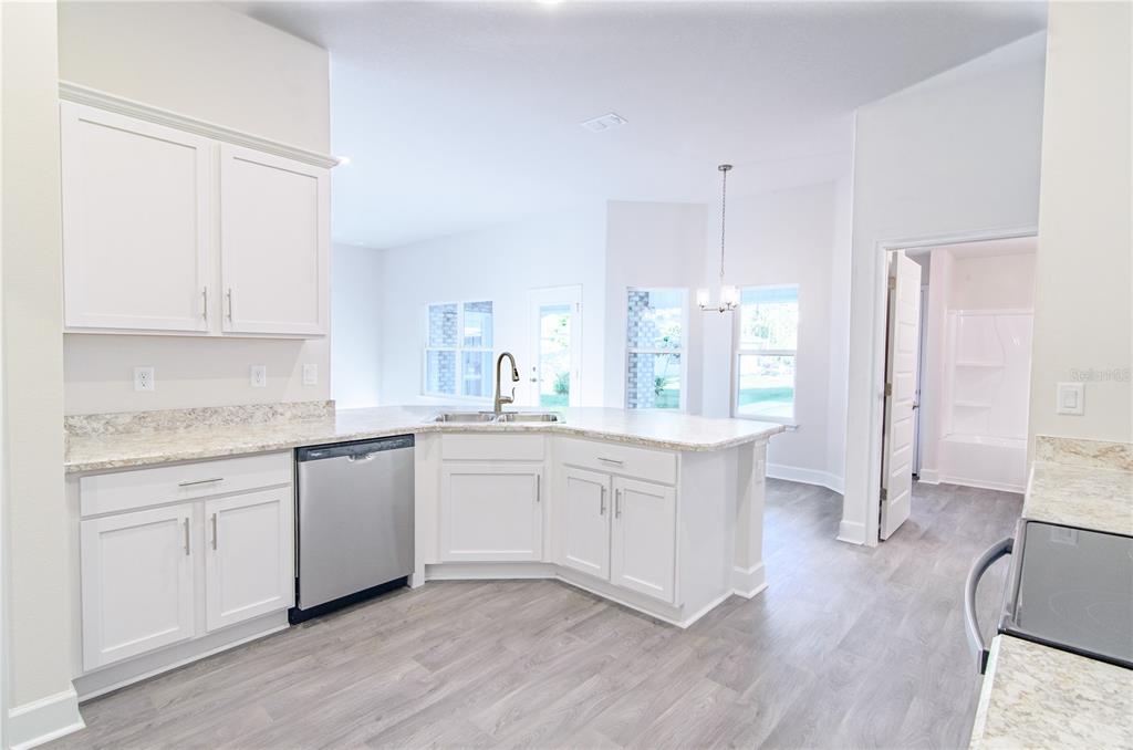 5 Red Clover Lane Palm Coast, FL 32164 - Photo 19 of 38 a kitchen with granite countertop white cabinets and white appliances