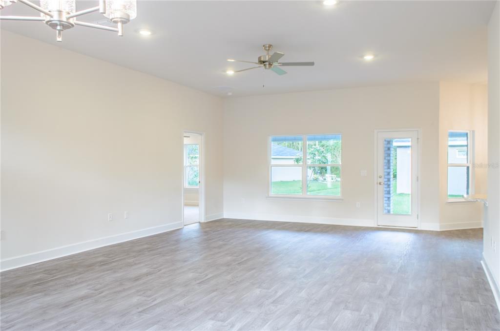 5 Red Clover Lane Palm Coast, FL 32164 - Photo 8 of 38 a view of an empty room with a window and wooden floor