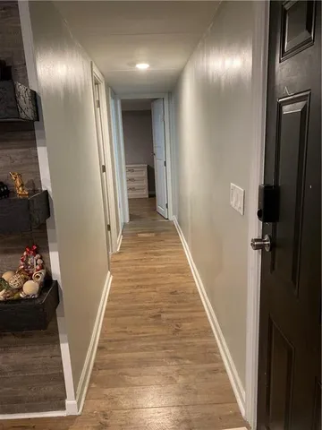 a view of hallway with stairs and wooden floor
