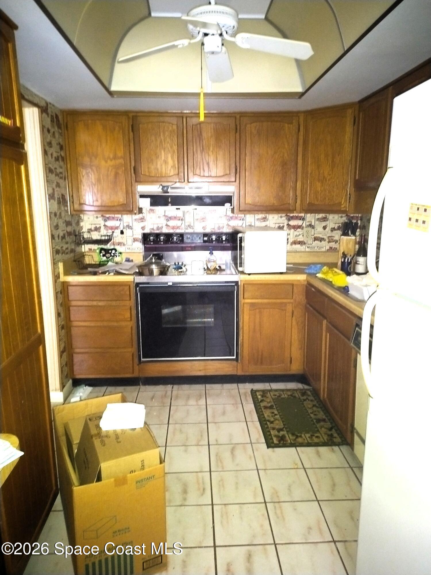 229 Kings Way Satellite Beach, FL 32937 - Photo 4 of 13 a kitchen with stainless steel appliances granite countertop a stove a sink and a microwave