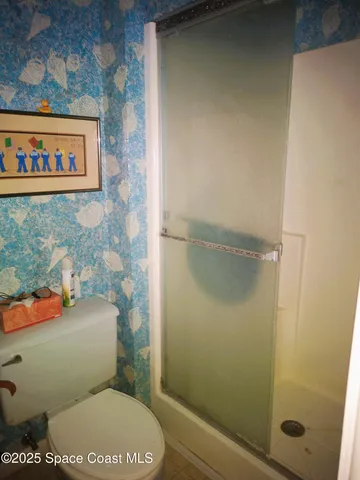 a bathroom with a toilet and a shower
