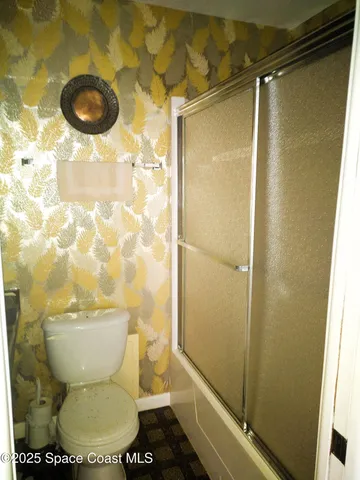 a bathroom with a toilet and a shower