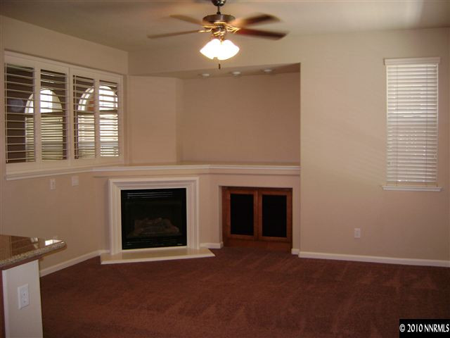 1845 A Wind Ranch Road Reno, NV 89521 - Photo 4 of 9 a view of a livingroom with a fireplace and a ceiling fan