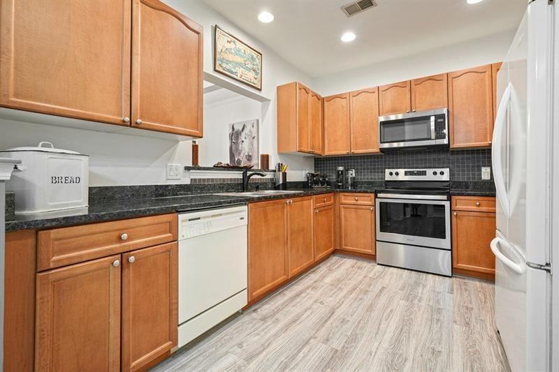 2521 Eden Ridge Lane, Unit 7 Acworth, GA 30101 - Photo 17 of 47 a kitchen with stainless steel appliances granite countertop a stove a sink and a microwave