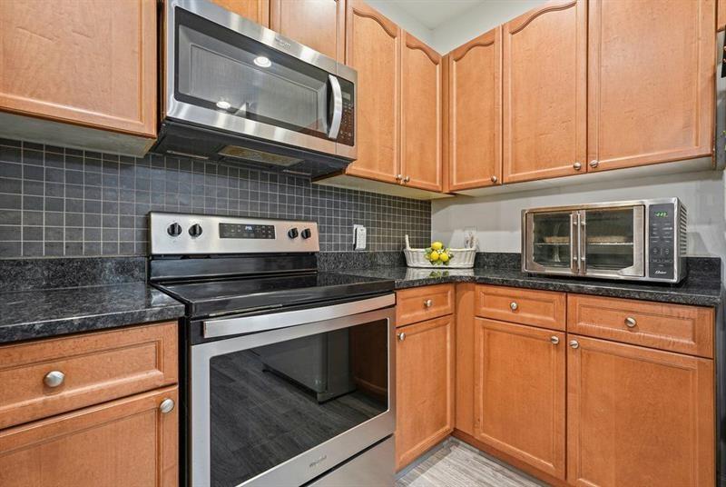 2521 Eden Ridge Lane, Unit 7 Acworth, GA 30101 - Photo 19 of 47 a kitchen with stainless steel appliances granite countertop white cabinets granite counter tops and a wooden floors