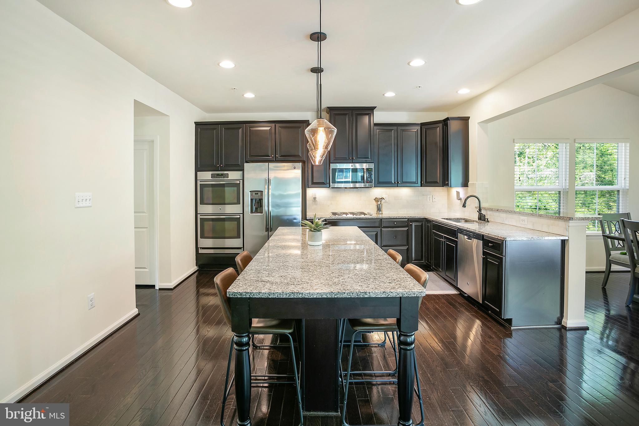 10576 Long Leaf Lane Waldorf, MD 20603 - Photo 2 of 54 a kitchen with stainless steel appliances granite countertop a kitchen island a stove a table and chairs in it