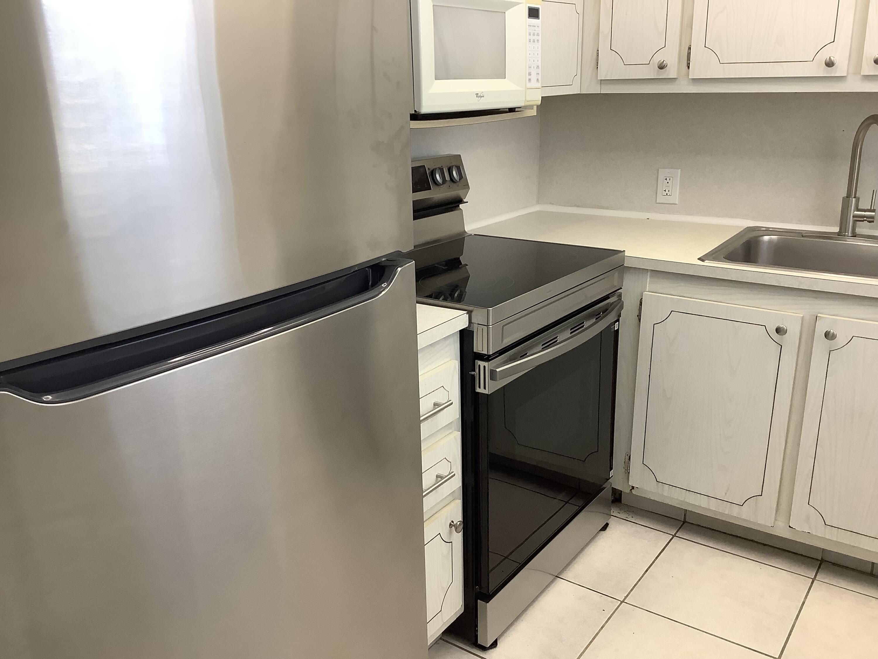 560 Fanshaw North, Unit 560 Boca Raton, FL 33434 - Photo 2 of 26 a kitchen with a refrigerator and cabinets