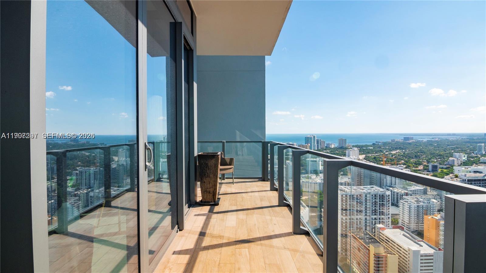 88 Southwest 7th Street, Unit 4106 Miami, FL 33130 - Photo 21 of 21 a view of a balcony with floor to ceiling windows with wooden floor