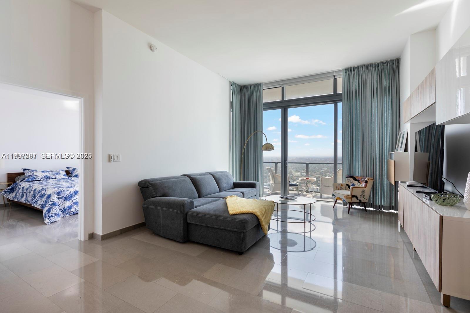 88 Southwest 7th Street, Unit 4106 Miami, FL 33130 - Photo 4 of 21 a living room with furniture and a flat screen tv