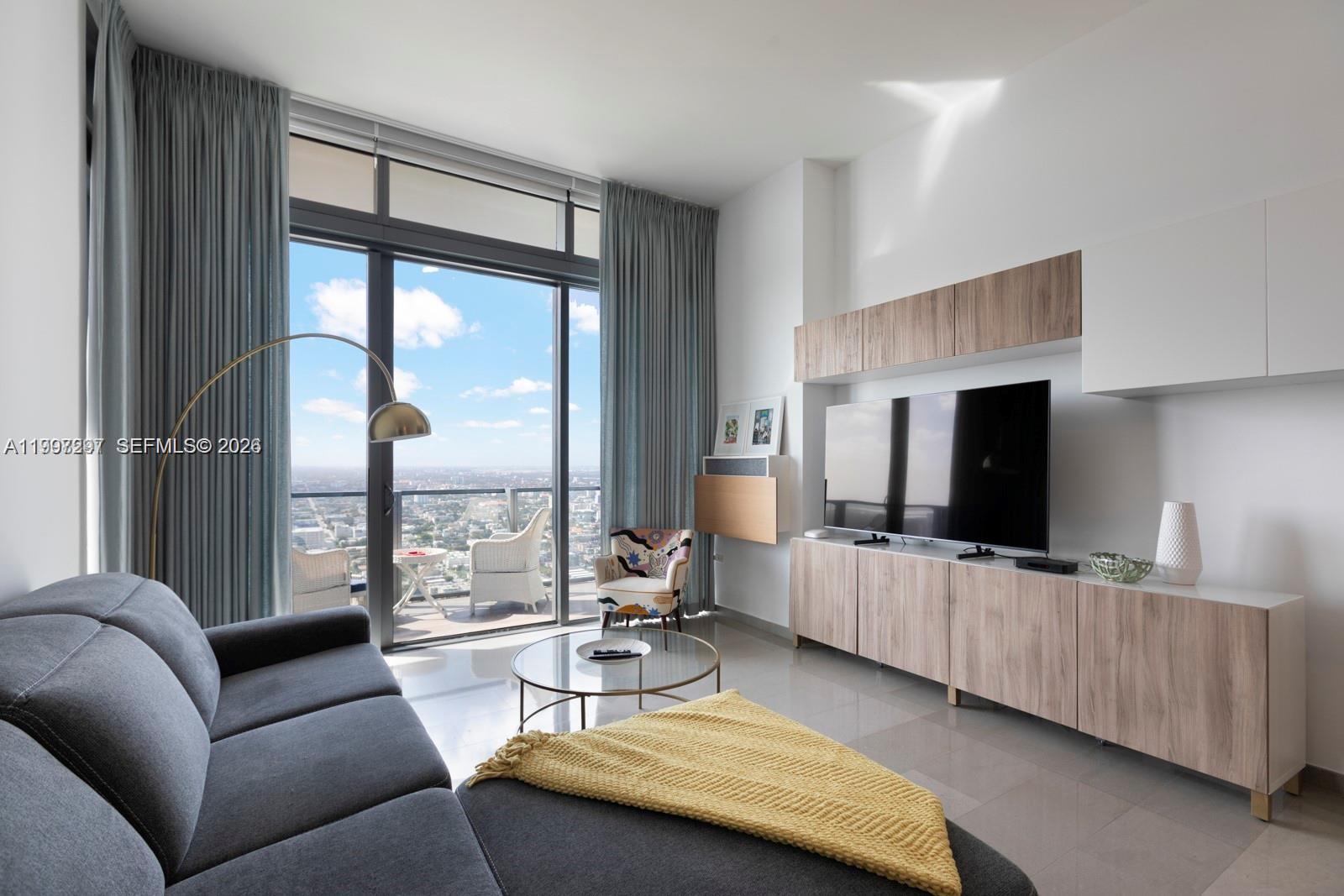 88 Southwest 7th Street, Unit 4106 Miami, FL 33130 - Photo 6 of 21 a living room with furniture and a flat screen tv