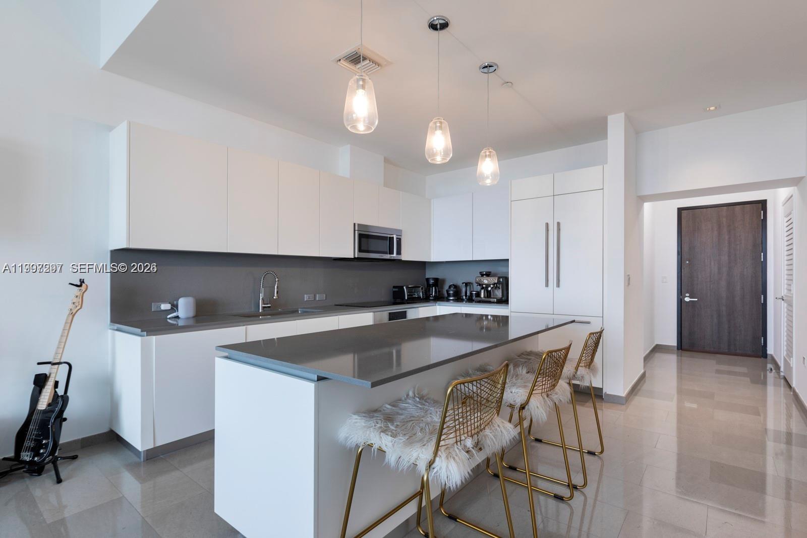 88 Southwest 7th Street, Unit 4106 Miami, FL 33130 - Photo 9 of 21 a kitchen that has a microwave a sink and cabinets