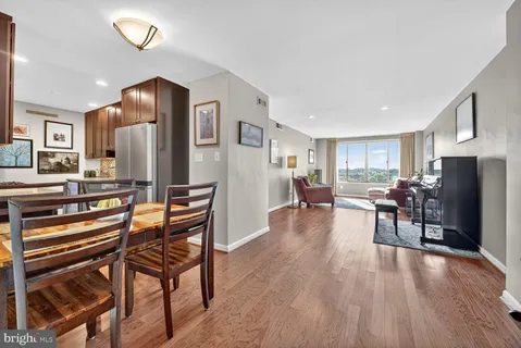 a living room with furniture a counter space and a refrigerator