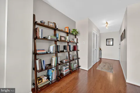 a view of a hallway with wooden floor and shoes