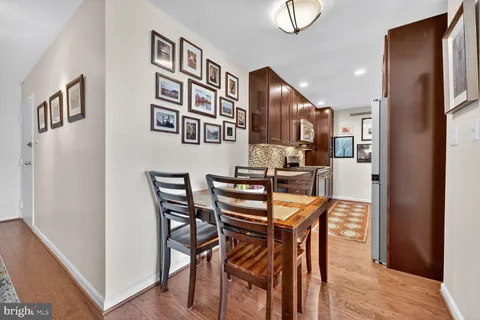 a dining room with stainless steel appliances kitchen island granite countertop a refrigerator and cabinets