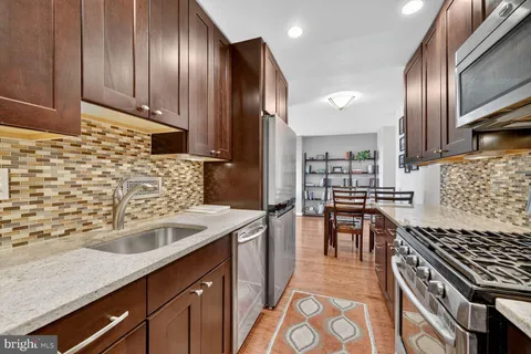 a kitchen with granite countertop stainless steel appliances and wooden cabinets