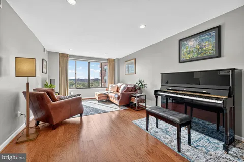 a living room with furniture a flat screen tv and a wall painting