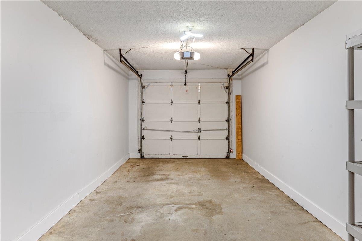 2976 Kin Cove, Unit 2976 Memphis, TN 38119 - Photo 23 of 24 Spacious garage featuring a sectional garage door, exposed ceiling joists, and concrete flooring