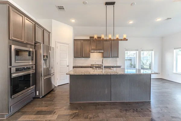 a kitchen with stainless steel appliances granite countertop a sink stove and refrigerator