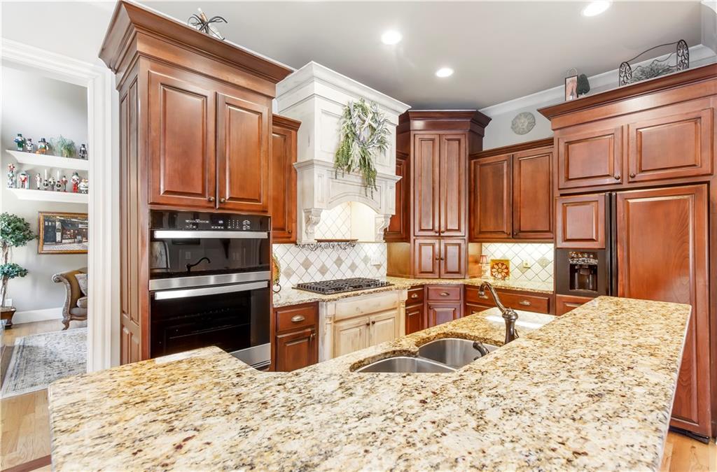 154 Gold Leaf Trail Powder Springs, GA 30127 - Photo 17 of 61 a kitchen with stainless steel appliances granite countertop a refrigerator sink and cabinets