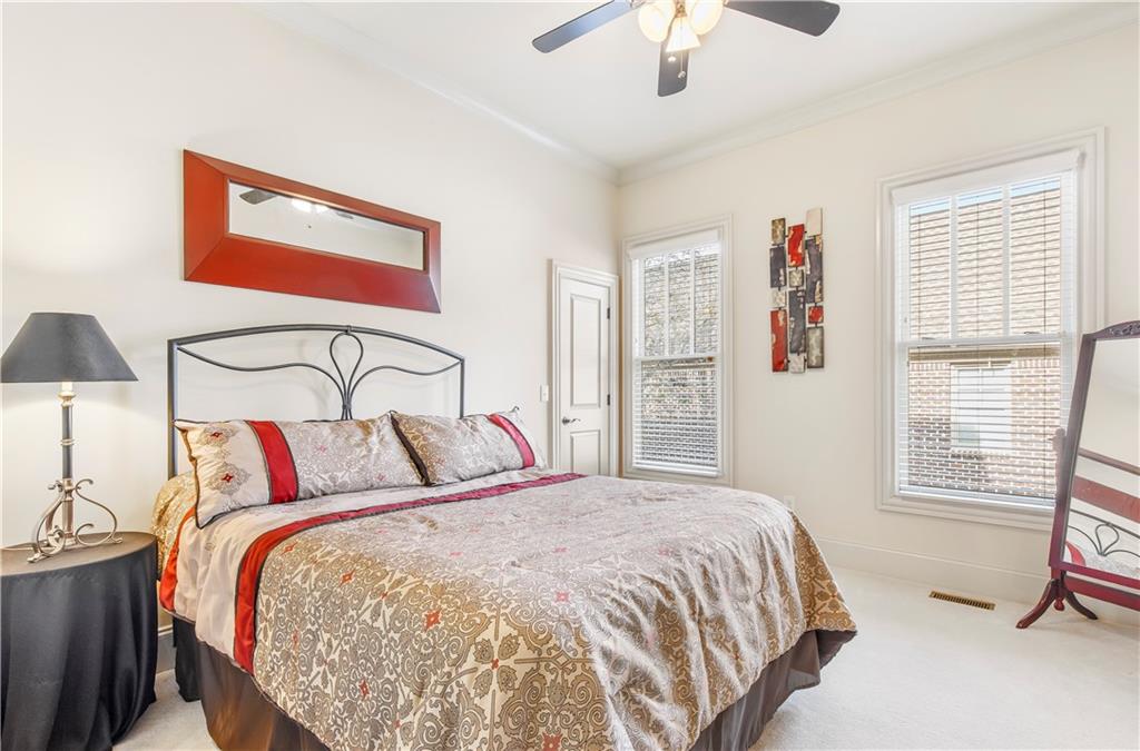 154 Gold Leaf Trail Powder Springs, GA 30127 - Photo 37 of 61 a bedroom with a large bed and a chandelier