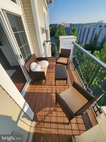 a balcony with wooden floor and outdoor seating