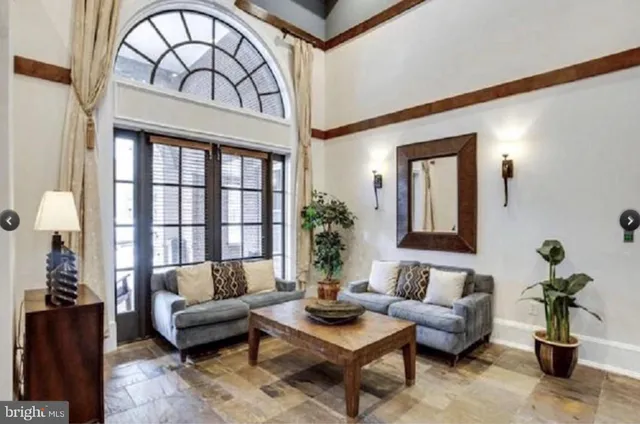 a living room with furniture a fireplace and potted plants