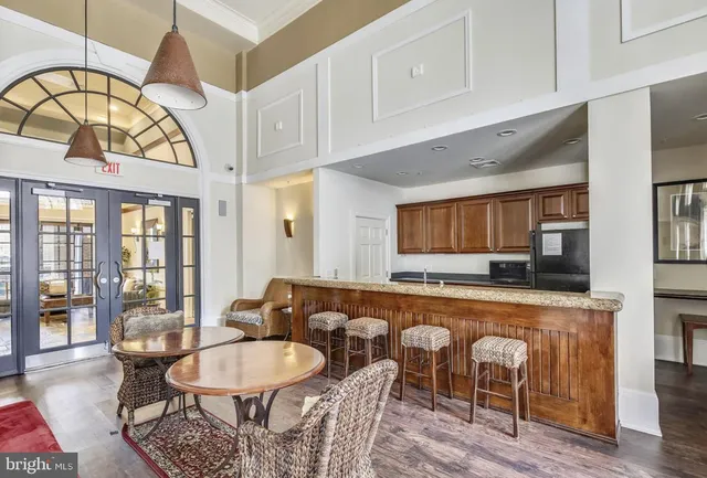 a living room with furniture a table and kitchen view