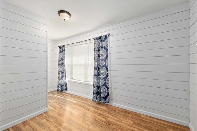 a view of empty room with window and wooden floor