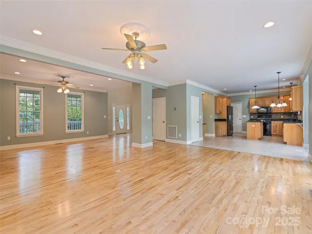 an empty room with wooden floor and chandelier