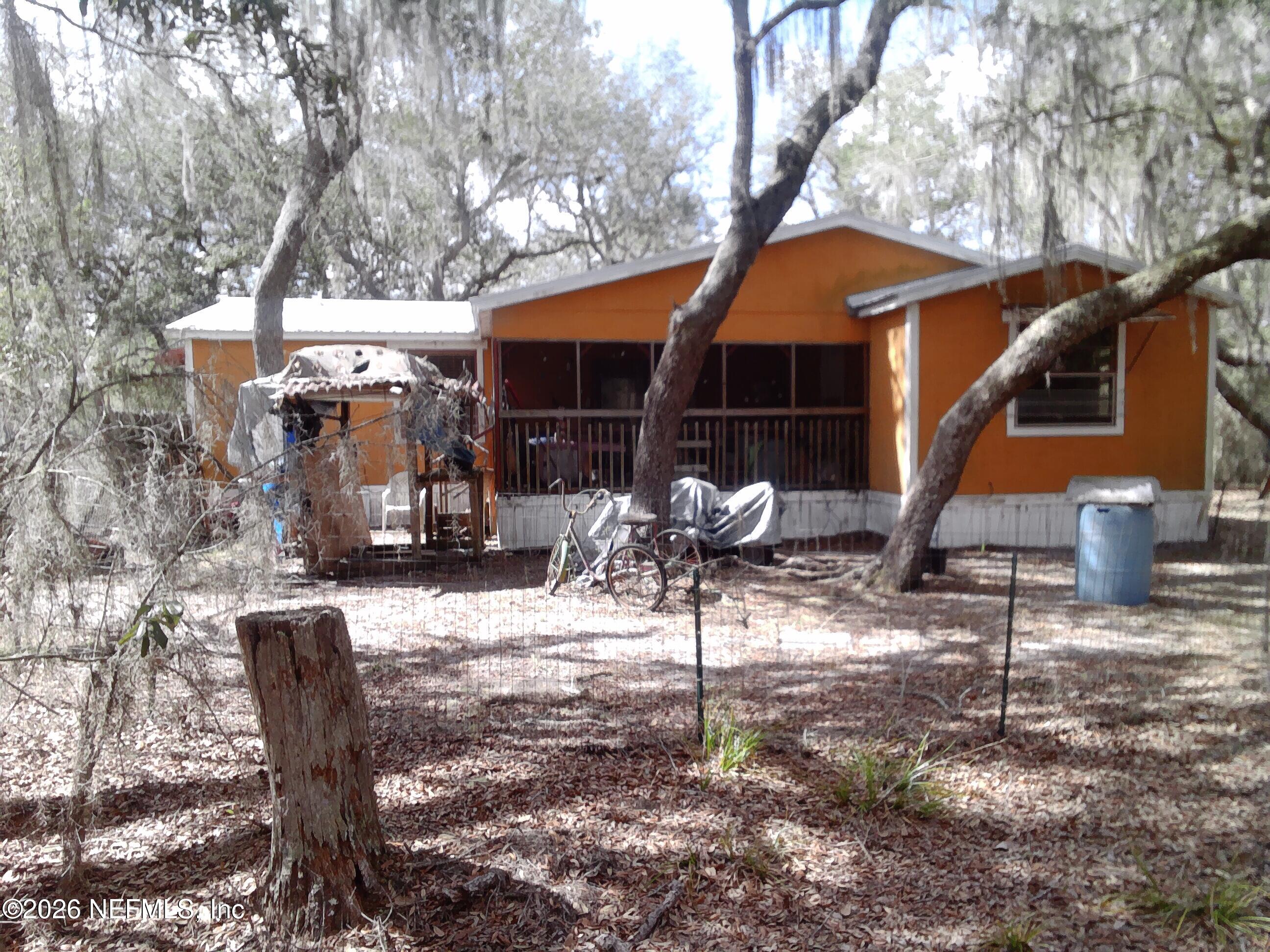 5816 Bryce Street Keystone Heights, FL 32656 - Photo 5 of 5 a backyard of a house with table and chairs