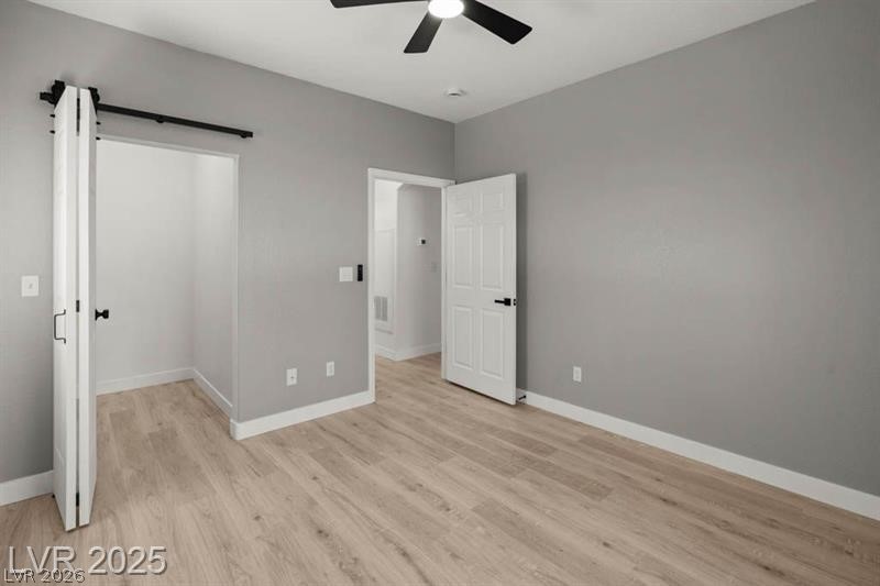 3320 South Fort Apache Road, Unit 125 Las Vegas, NV 89117 - Photo 18 of 26 Bright, neutral-toned bedroom with durable flooring and modern barn door closet.