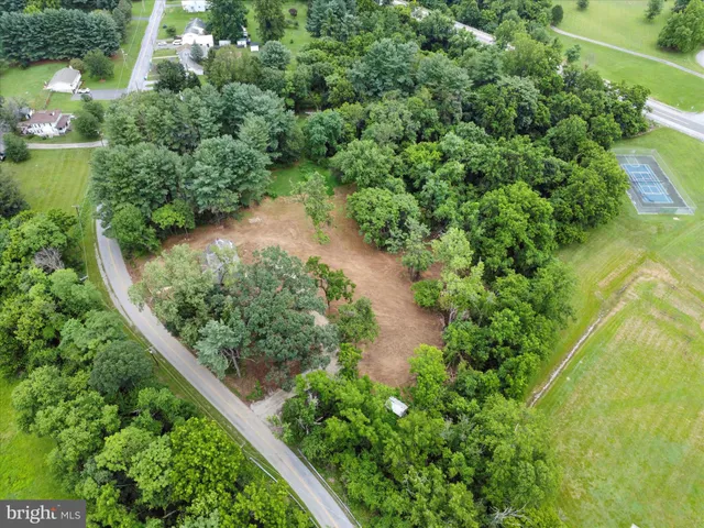an aerial view of residential house with outdoor space and trees all around