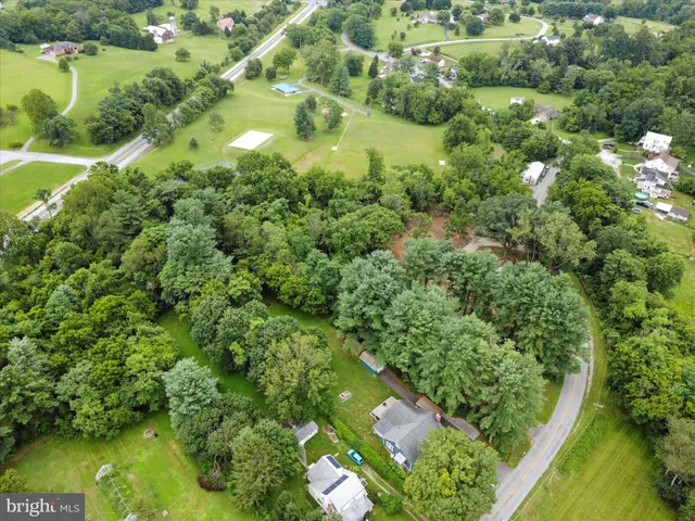 an aerial view of residential houses with outdoor space and trees