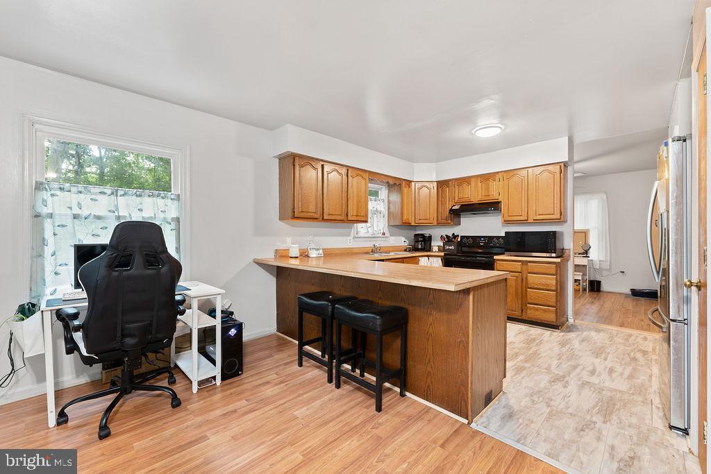 127 Saylers Creek Road Locust Grove, VA 22508 - Photo 32 of 56 a open kitchen with stainless steel appliances granite countertop a stove top oven a refrigerator a dining table and chairs with the wooden floor